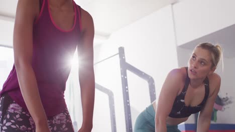 Video-De-Dos-Mujeres-Diversas-Y-Exhaustas-Chocando-Las-Manos-Después-De-Hacer-Ejercicio-En-Un-Gimnasio.