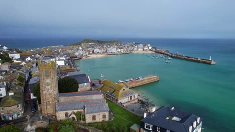 St-Ives-Church-with-a-Panning-Shot-Overlooking-the-Turquoise-Harbor-in-Cornwall-on-a-Beautiful-Summer's-Day-in-England-from-an-Aerial-Drone-Shot