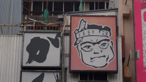 close-up of japanese street signs featuring a cartoon character and sushi text