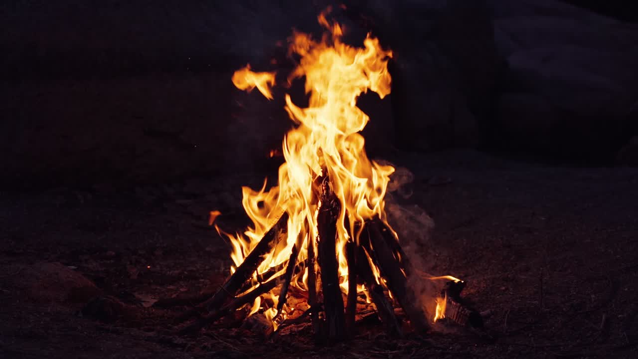 Bonfire burning at night. Flames of fire on black background in slow motion.