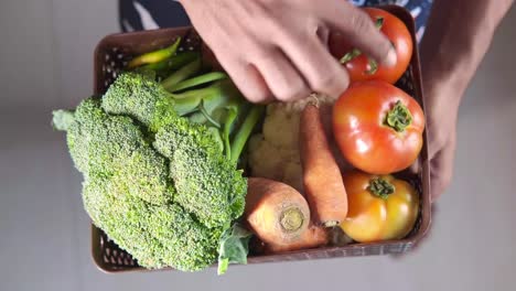 person holding a basket of fresh vegetables