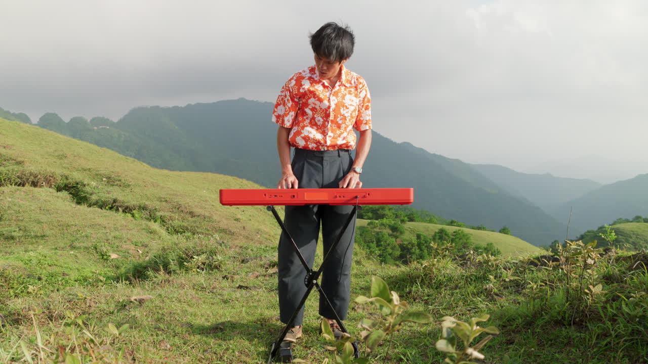 태양이 그를 비추는 밖에서 피아노를 연주하는 남자의 느린 동작 클립