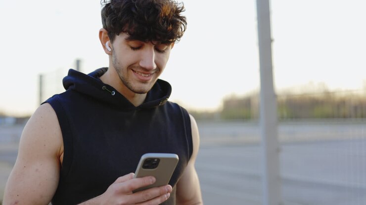 hombre usando teléfono inteligente al aire libre
