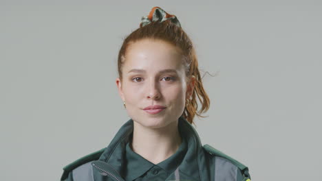 retrato de estudio de una joven paramédica seria contra un fondo plano