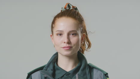 portrait de studio d'une jeune femme ambulancière sérieuse sur un fond ordinaire