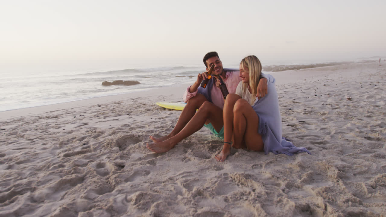 una pareja caucásica disfrutando del tiempo en la playa.