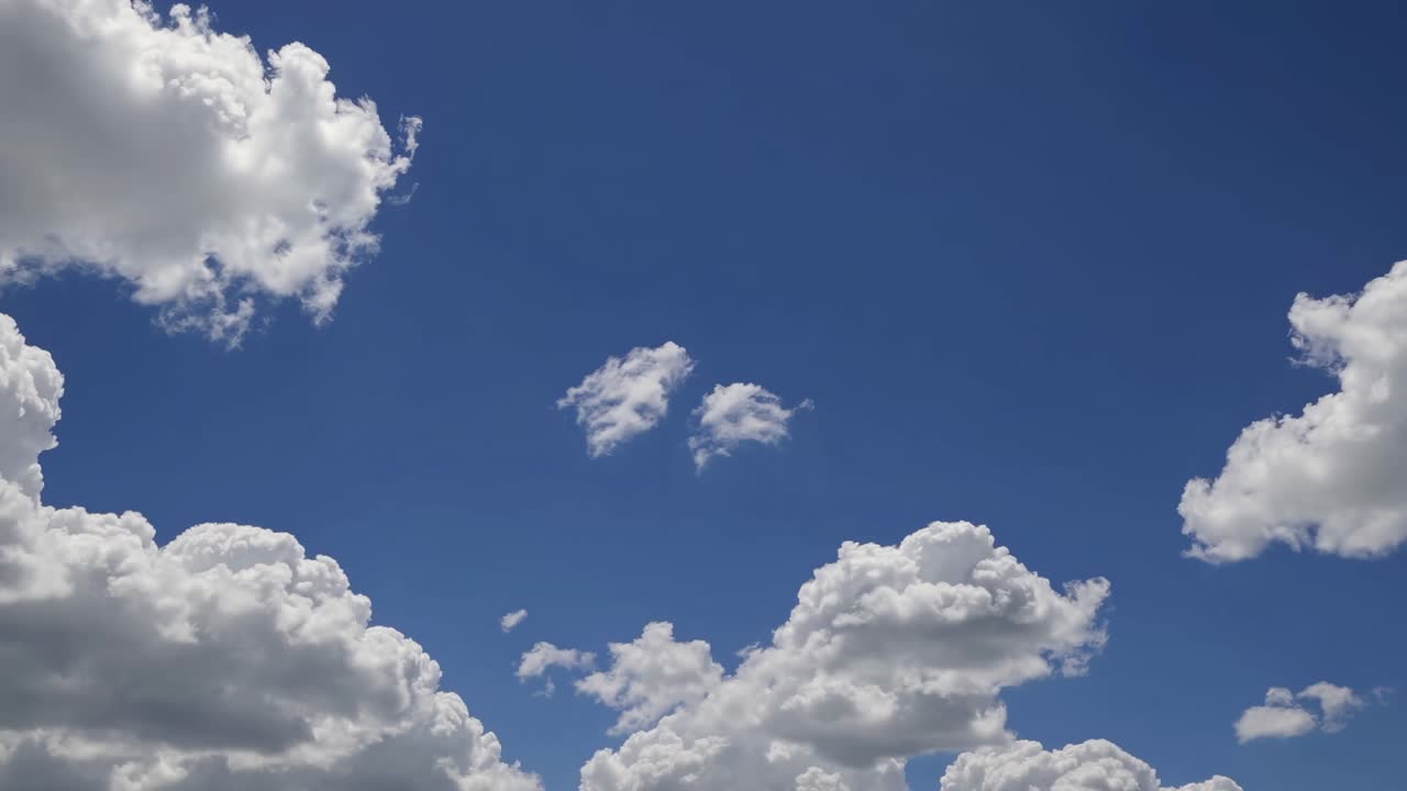 Video captures a serene sky with fluffy clouds from a low-angle perspective