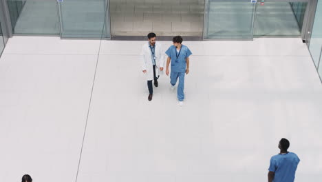 overhead view of medical staff walking through lobby of modern hospital building