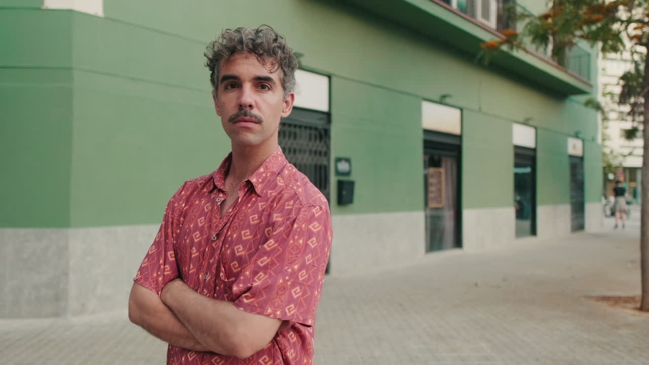 Confident Man with Mustache Standing on Urban Sidewalk