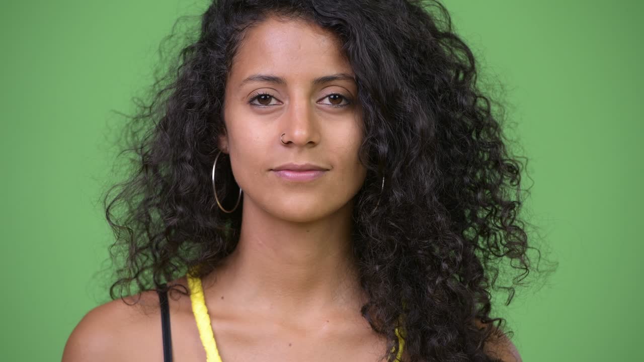 Young happy beautiful Hispanic woman with curly hair