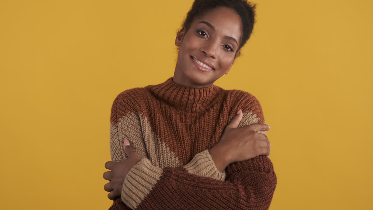 Una mujer feliz abrazándose a sí misma.