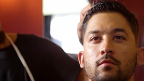 barbero peinando el cabello del cliente 4k