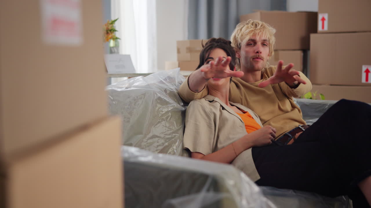Happy Young Couple Discussing Plans in Their New Home Surrounded by Moving Boxes