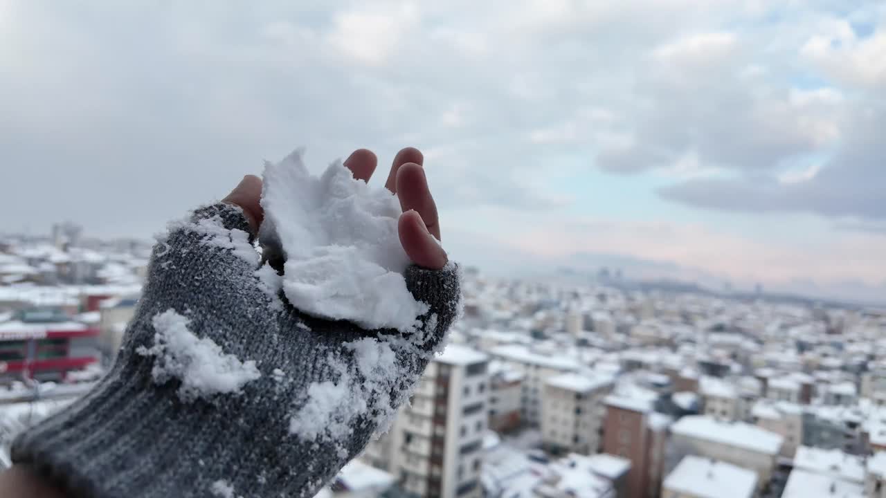 Snowy Cityscape with Hand Holding Snowball