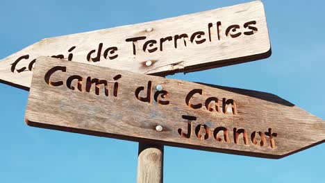 wooden sign indicating roads in catalan in mallorca