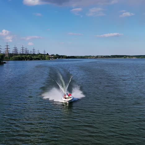 boat sailing in the river. people travel in motorboat on the background of high voltage electric lines in summer. aerial view.