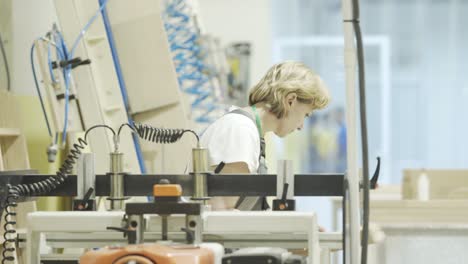 woman working on woodworking machine in a workshop