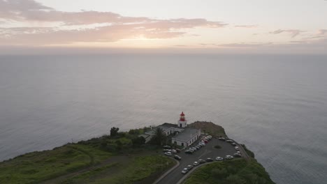 Drohnenaufnahme-Eines-Leuchtturms-Auf-Einem-Hügel-Und-Blick-Auf-Das-Meer