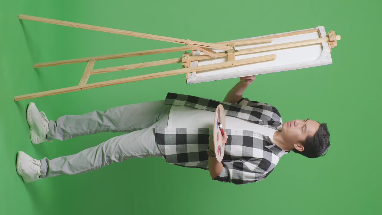 artista con suministros de pintura delante del caballete