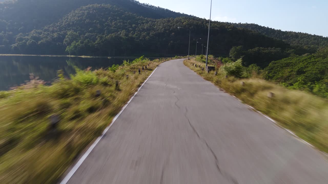 Volo sopra una strada e poi sopra un lago in Thailandia.