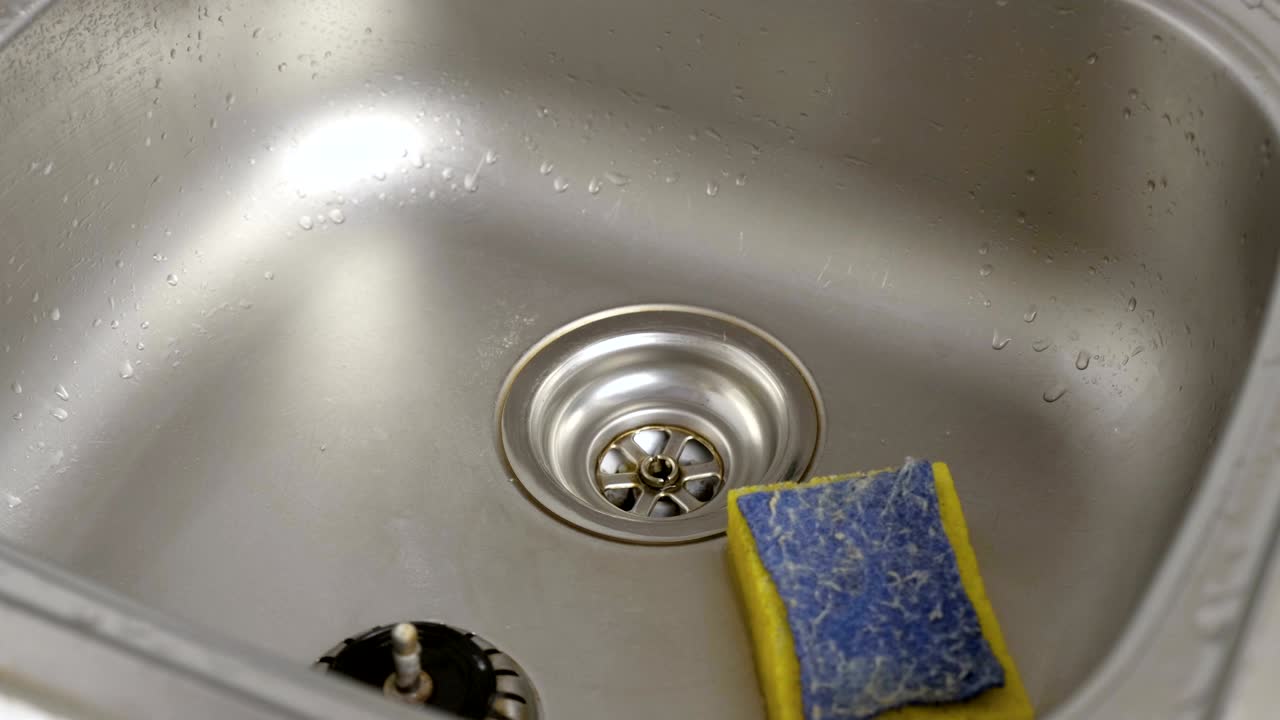 Svamp til opvask i en metalvask i køkkenet