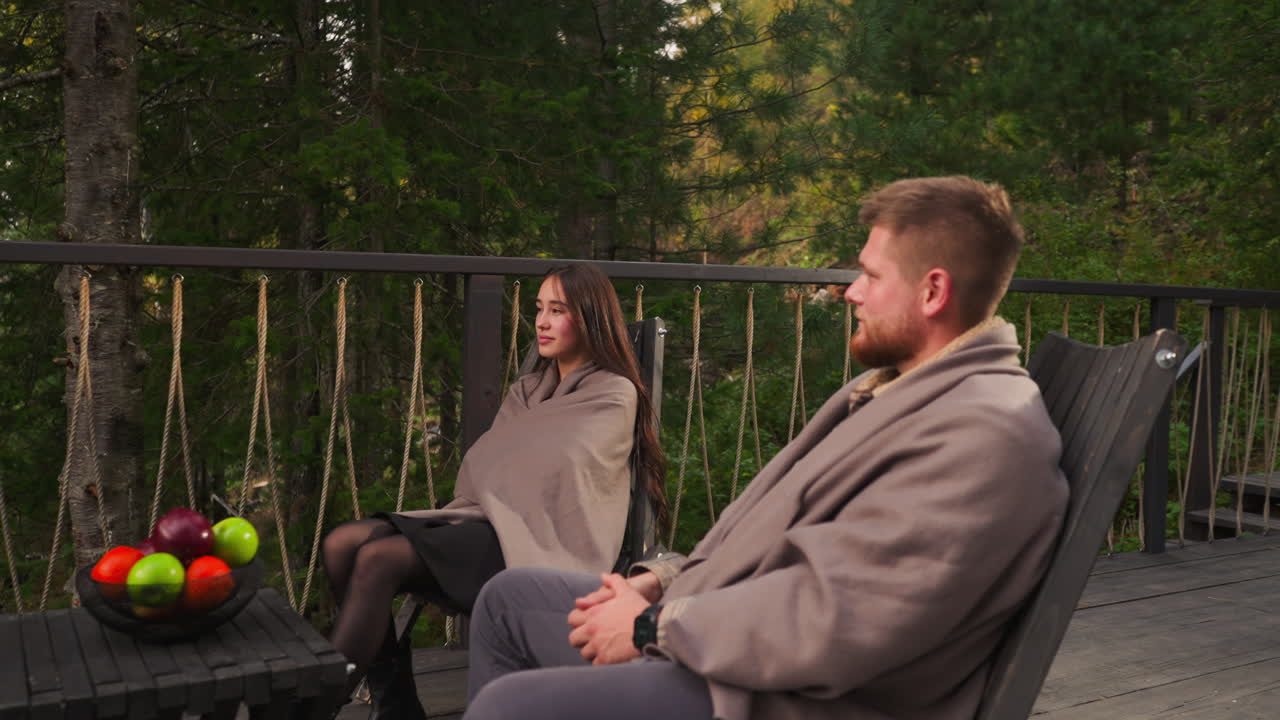 한 부부가 숲 속 의 나무 갑판 에서 휴식을 취하고 있다