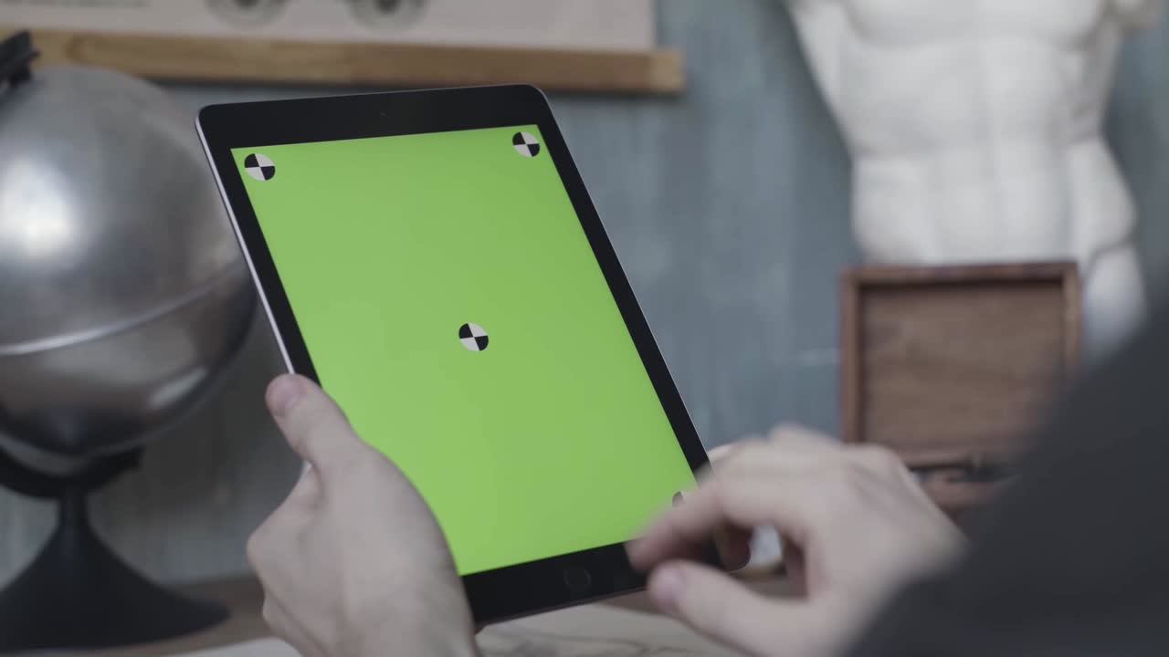 persona que utiliza una tableta con pantalla verde para la calibración