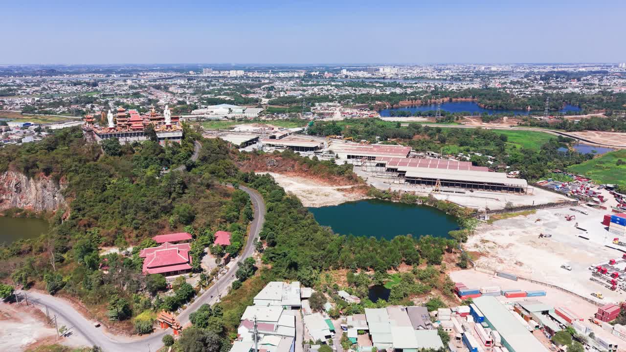 Vista aérea de canteiro de obras perto do lago com a cidade ao fundo, tomada diurna