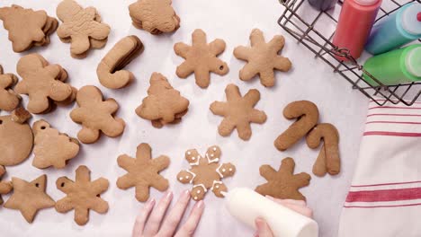 decorating gingerbread cookies with royal icing for christmas.