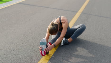 Handicapped-girl-stretching-legs-on-road.-Runner-warming-after-workout