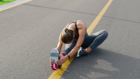 handicapped girl stretching legs on road. runner warming after workout