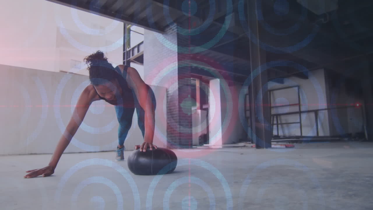 Exercising with medicine ball, woman with digital animation overlay in gym