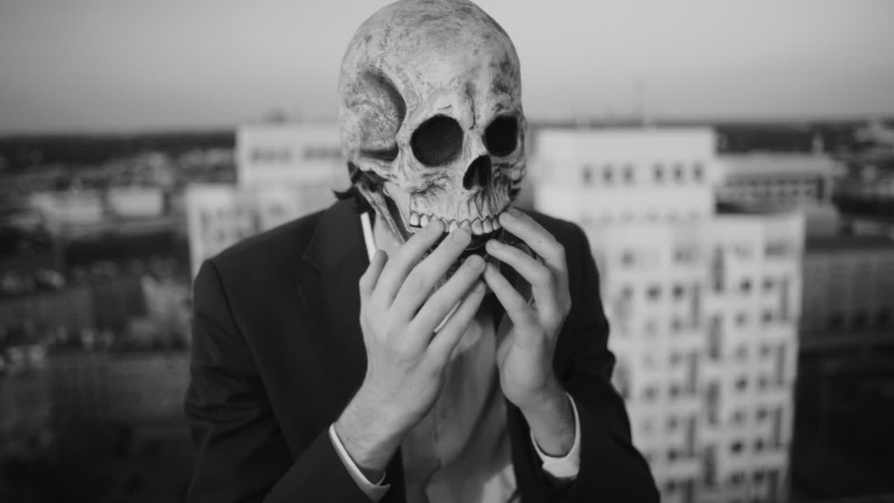 Man in Skull Mask on Rooftop in Black and White