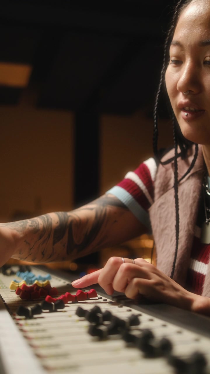 Asian Female Sound Designer Using Mixing Console in Recording Studio