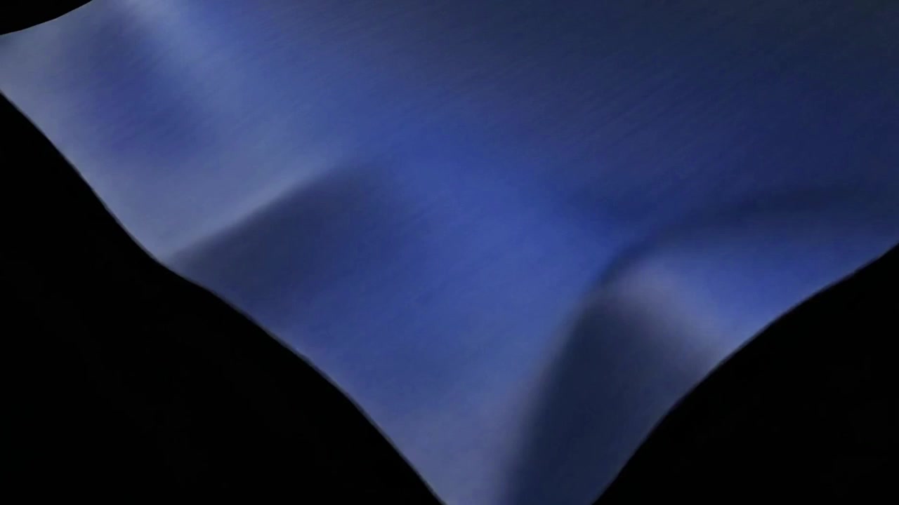 Blue Fabric Unfolding Against a Black Background