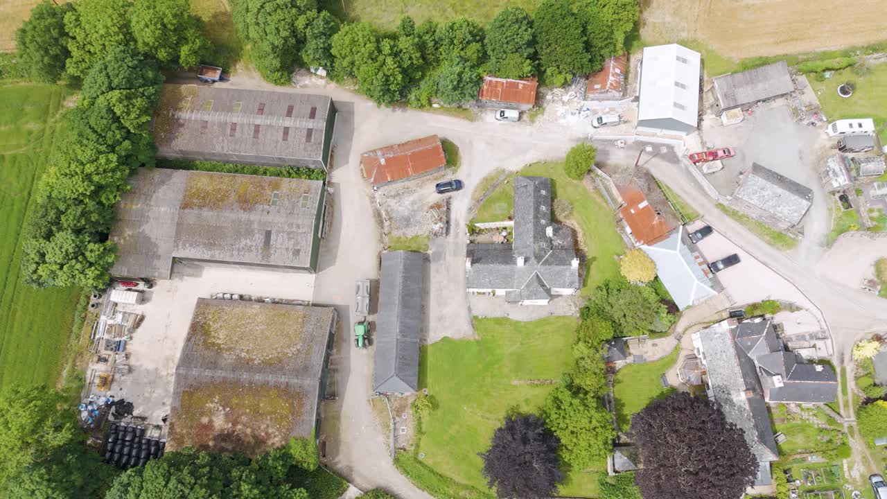 영국 데본의 소규모 농장 외관으로 건물, 초록색, 시골 주변을 보여줍니다.