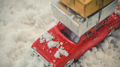 red model car with presents on its roof combined with falling snow