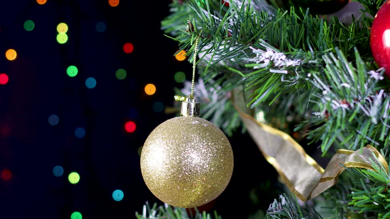 ornamento de oro brillante balancearse y moverse en el árbol de navidad