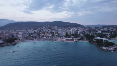 aerial over ksamil shore into the cityscape at dusk, albania