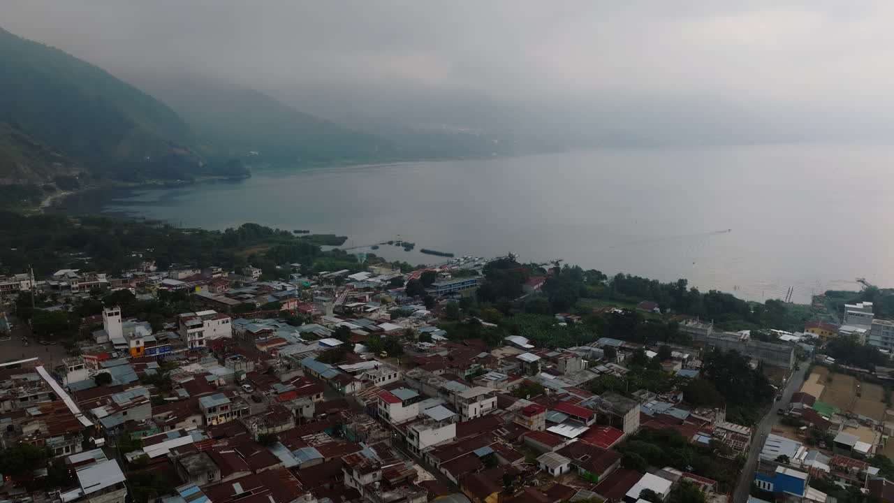 desde el aire: vista de la orilla del lago de la aldea de san juan la laguna en guatemala durante un día nublado