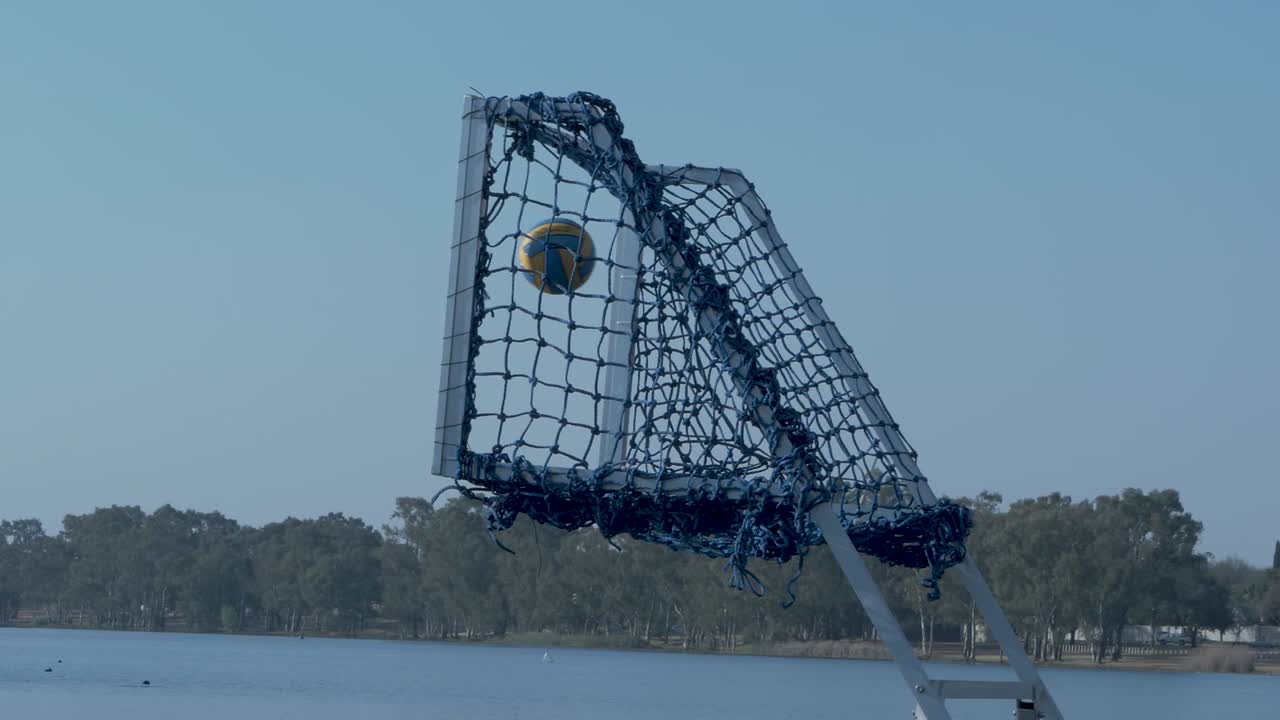 Ball going into net goal on water and bouncing around in slow motion