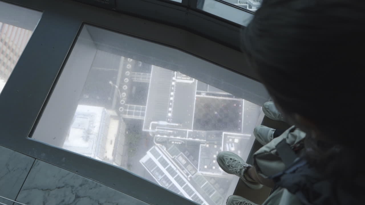 turistas caminando por el piso de vidrio de la torre en el centro de la ciudad de auckland, nueva zelanda
