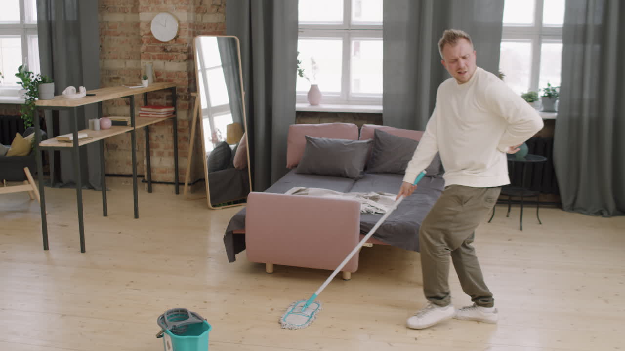 Young Man Dancing and Cleaning at Home