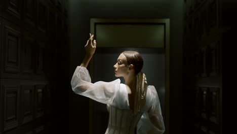 elegant woman in a white dress in a dark room