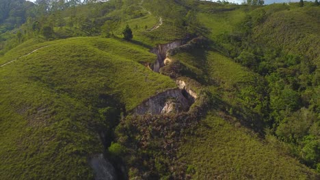 drone moves away from natural cracks as a whole mountain is revealed during a sunset