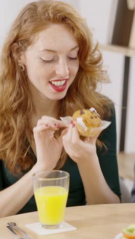 woman enjoying a muffin and orange juice