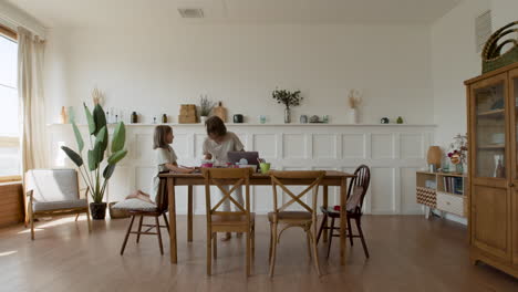 Wide-Shot-Of-A-Blonde-Girl-Doing-Her-Homework-In-Her-Living-Room