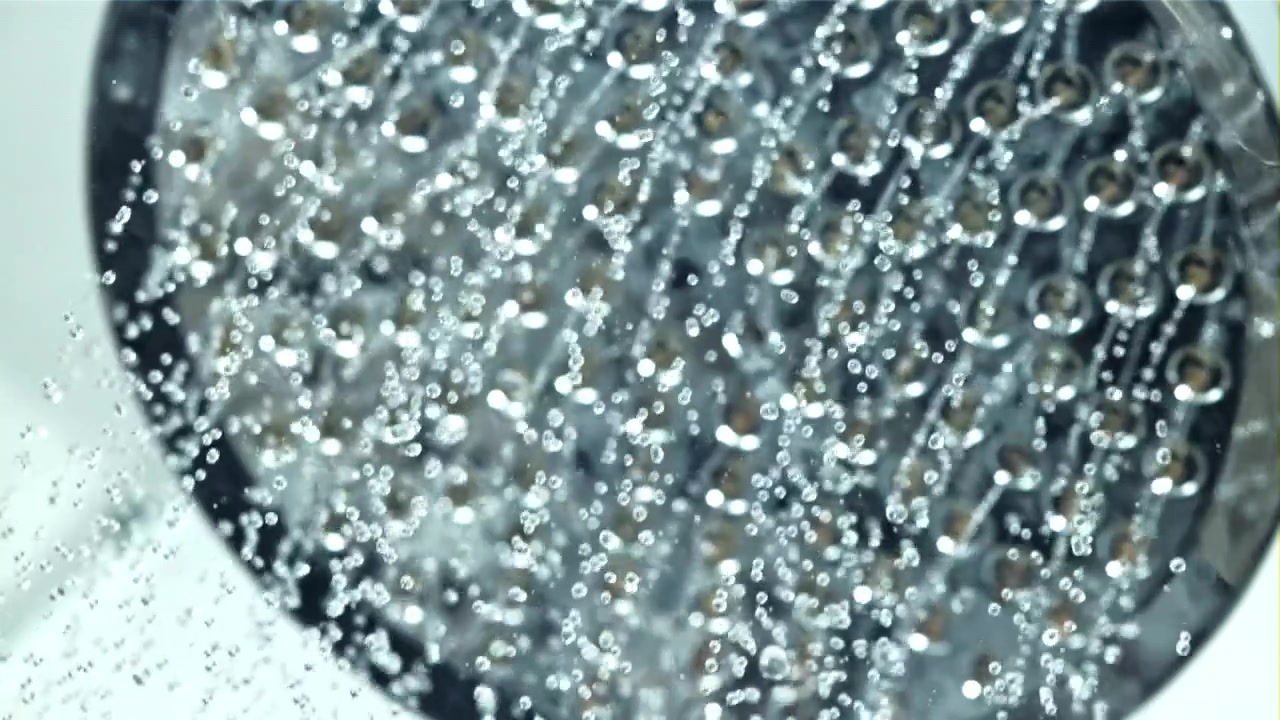 Primo piano di acqua limpida che fuoriesce da un soffione doccia