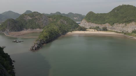 Aerial-to-secluded-sand-beach-on-Cat-Ba-Island-in-Ha-Long-Bay,-Vietnam