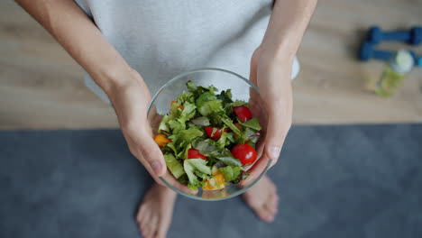 person holding a bowl of salad